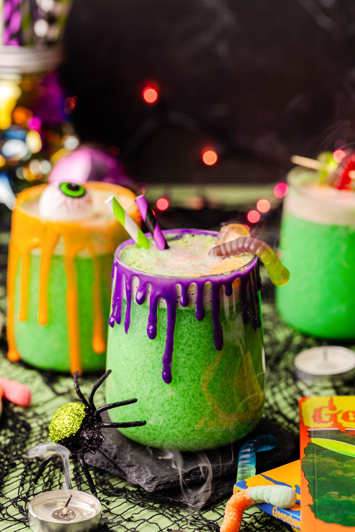Close up photo of glasses of Halloween punch on a table with decorations scattered around.