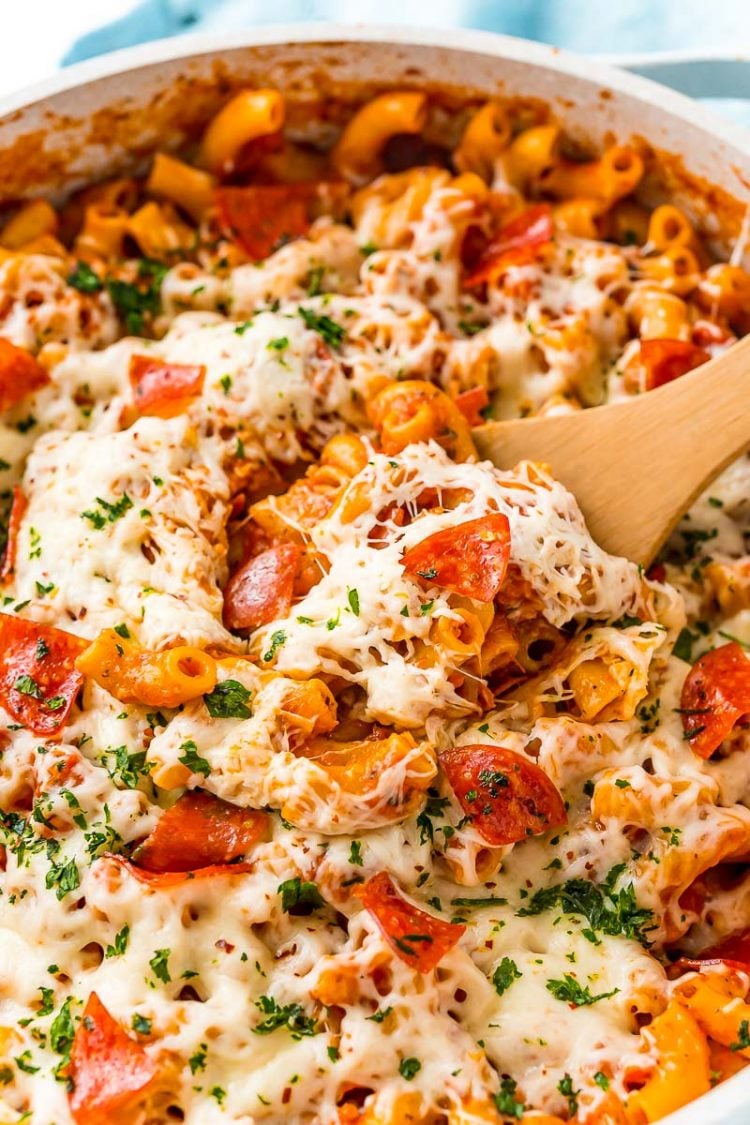 Close up photo of pizza pasta with a wooden serving spoon.