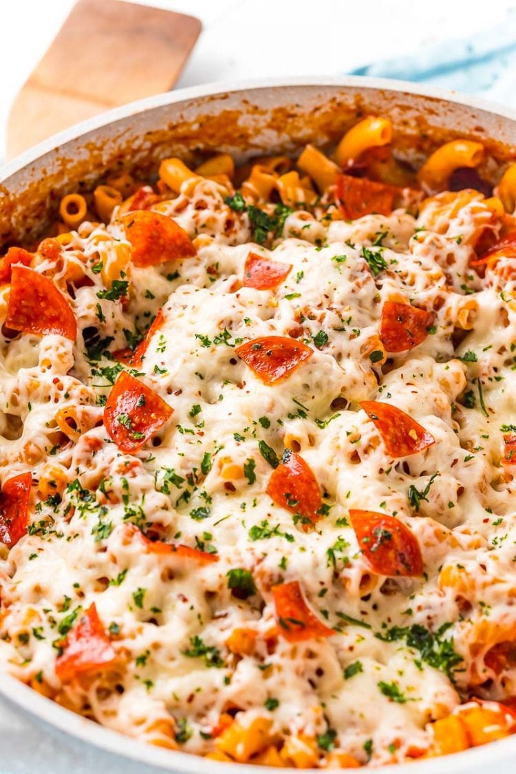 Close up photo of pasta cookies with pepperoni, cheese, and red sauce.