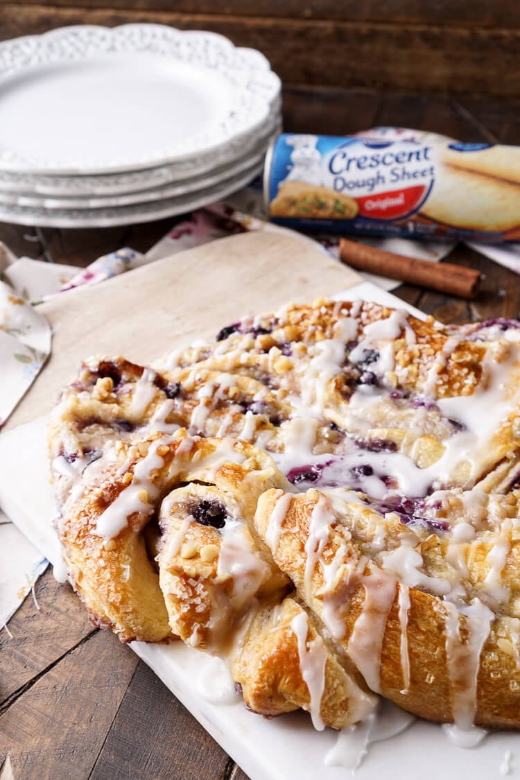 This Blueberry Spice Cream Cheese Breakfast Ring is the perfect addition to a holiday brunch. A simple and sweet filling is wrapped up in crescent dough and topped with chopped pecans and icing for a delicious morning pastry the whole family can enjoy!