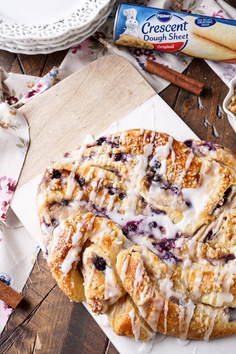 This Blueberry Spice Cream Cheese Breakfast Ring is the perfect addition to a holiday brunch. A simple and sweet filling is wrapped up in crescent dough and topped with chopped pecans and icing for a delicious morning pastry the whole family can enjoy!