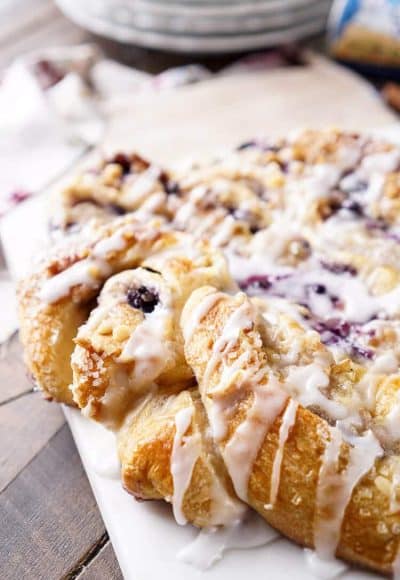 This Blueberry Spice Cream Cheese Breakfast Ring is the perfect addition to a holiday brunch. A simple and sweet filling is wrapped up in crescent dough and topped with chopped pecans and icing for a delicious morning pastry the whole family can enjoy!