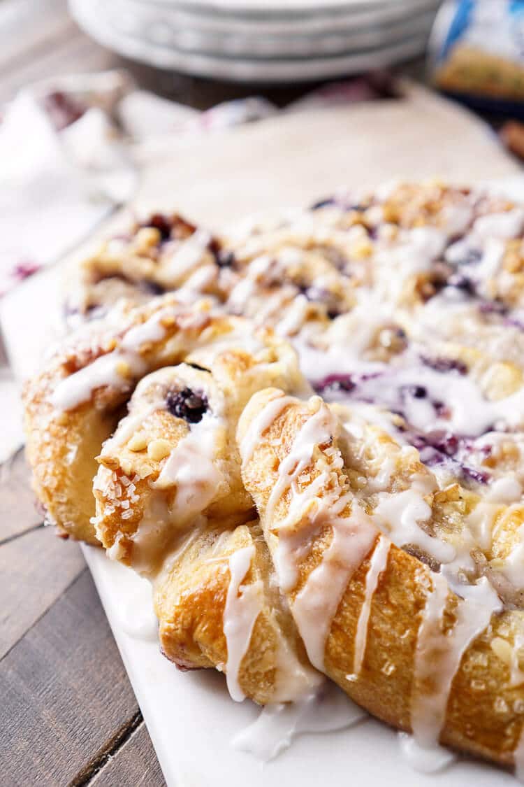 This Blueberry Spice Cream Cheese Breakfast Ring is the perfect addition to a holiday brunch. A simple and sweet filling is wrapped up in crescent dough and topped with chopped pecans and icing for a delicious morning pastry the whole family can enjoy!