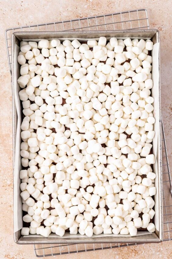 Mini marshmallows on top of brownies in a 9x13-inch pan.