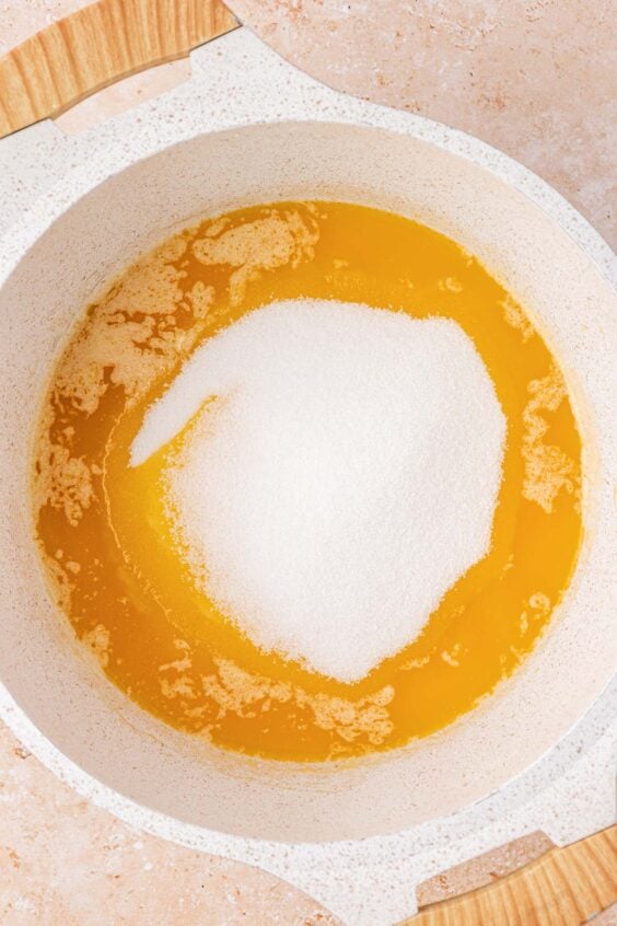 Sugar added to melted butter in a pot.