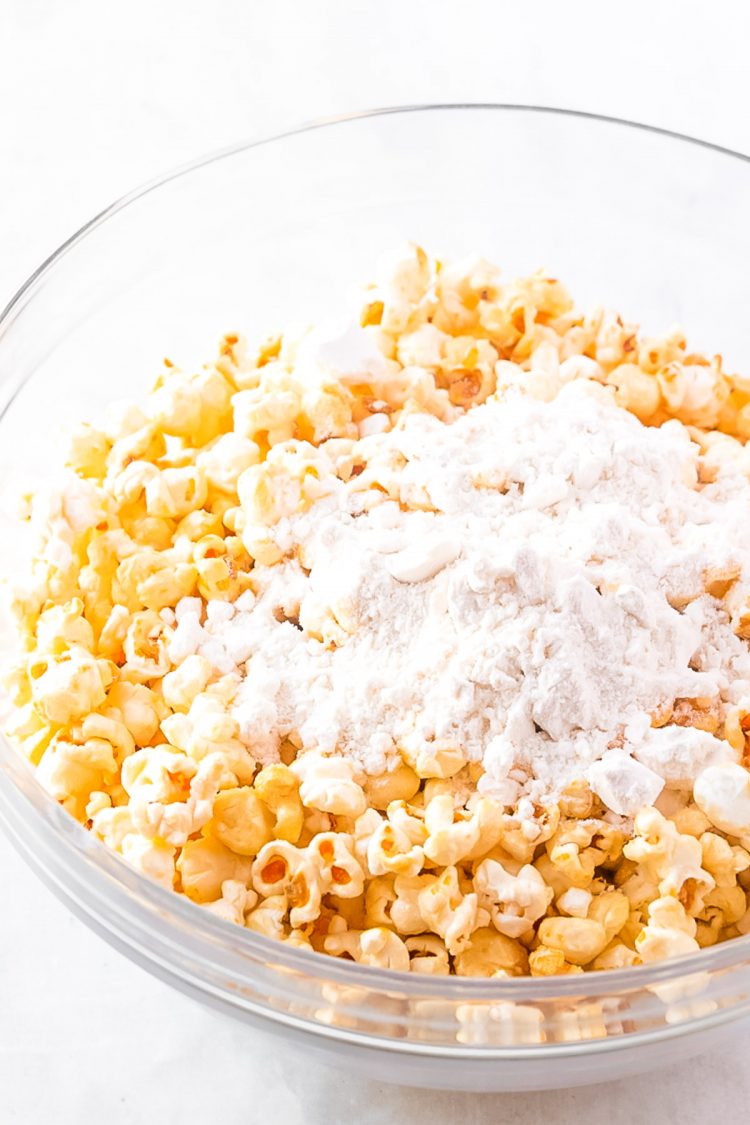 popcorn and dry cake mix in a a glass mixing bowl.