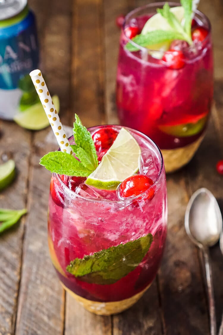 A class of cranberry mojito on a wooden table.