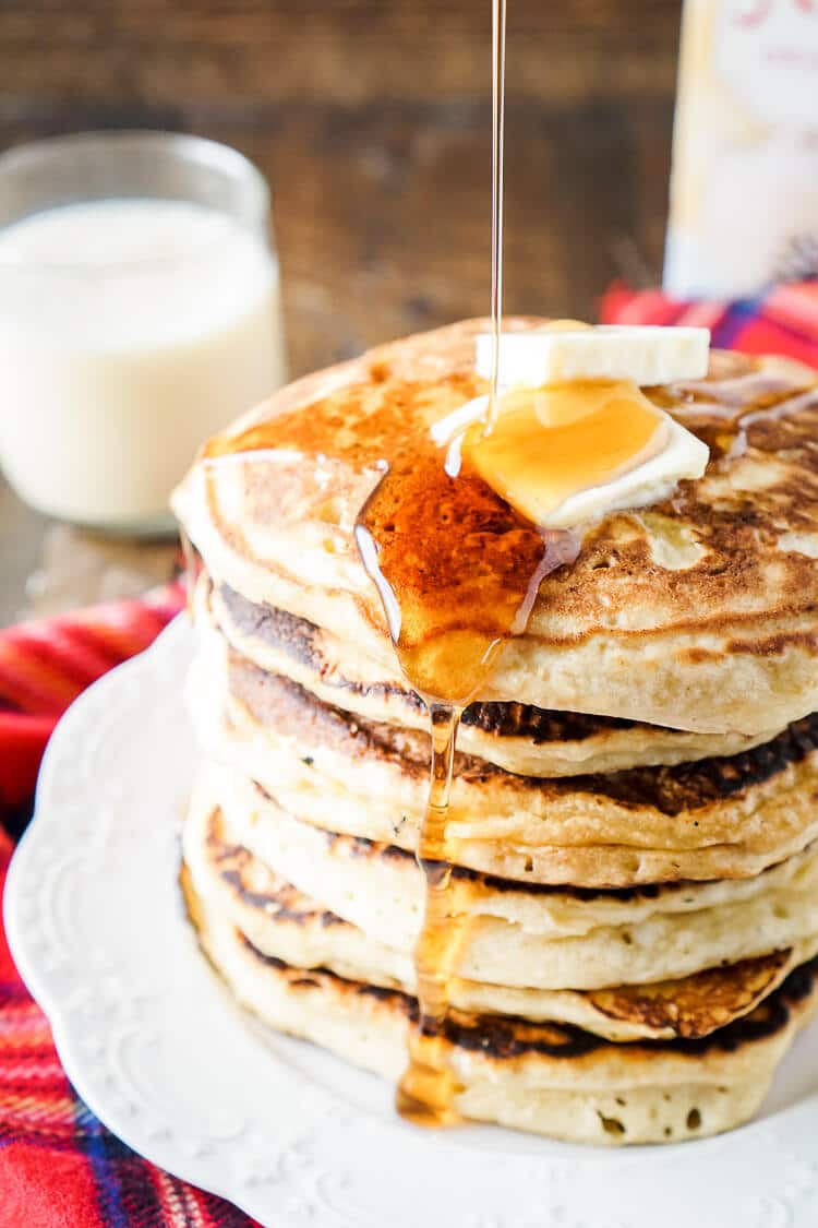 These Eggnog Ricotta Pancakes are fluffy and full of holiday flavor! Made with a creamy eggnog and ricotta base, these cook right up in minutes and make a fantastic holiday breakfast! Top them with butter, syrup, and whipped cream!