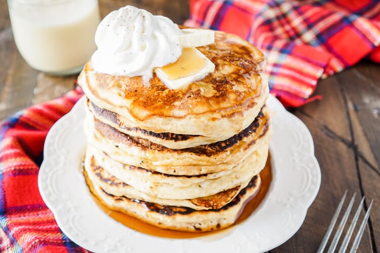 These Eggnog Ricotta Pancakes are fluffy and full of holiday flavor! Made with a creamy eggnog and ricotta base, these cook right up in minutes and make a fantastic holiday breakfast! Top them with butter, syrup, and whipped cream!