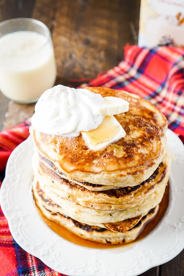 These Eggnog Ricotta Pancakes are fluffy and full of holiday flavor! Made with a creamy eggnog and ricotta base, these cook right up in minutes and make a fantastic holiday breakfast! Top them with butter, syrup, and whipped cream!