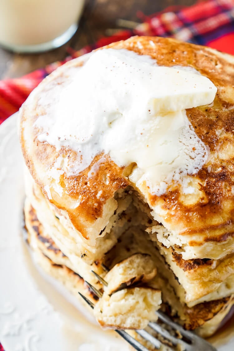 These Eggnog Ricotta Pancakes are fluffy and full of holiday flavor! Made with a creamy eggnog and ricotta base, these cook right up in minutes and make a fantastic holiday breakfast! Top them with butter, syrup, and whipped cream!