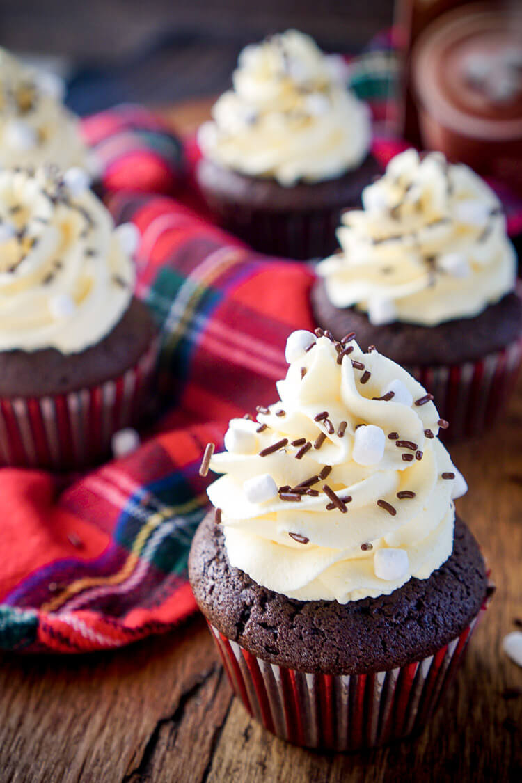 These Hot Chocolate Cupcakes are made with actual hot chocolate in the batter, filled with marshmallow fluff, and finished with a vanilla whipped cream frosting! They're everything you love about the classic drink in cupcake form, a perfect winter and holiday dessert!