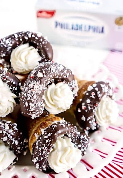 These Chocolate Peppermint Cheesecake Cream Horns are a simple dessert with a flaky pastry that’s been dipped in chocolate, sprinkled with peppermint candy pieces, and finished with a peppermint cream cheese filling.