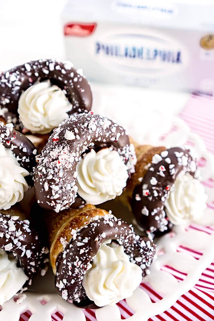 These Chocolate Peppermint Cheesecake Cream Horns are a simple dessert with a flaky pastry that’s been dipped in chocolate, sprinkled with peppermint candy pieces, and finished with a peppermint cream cheese filling.