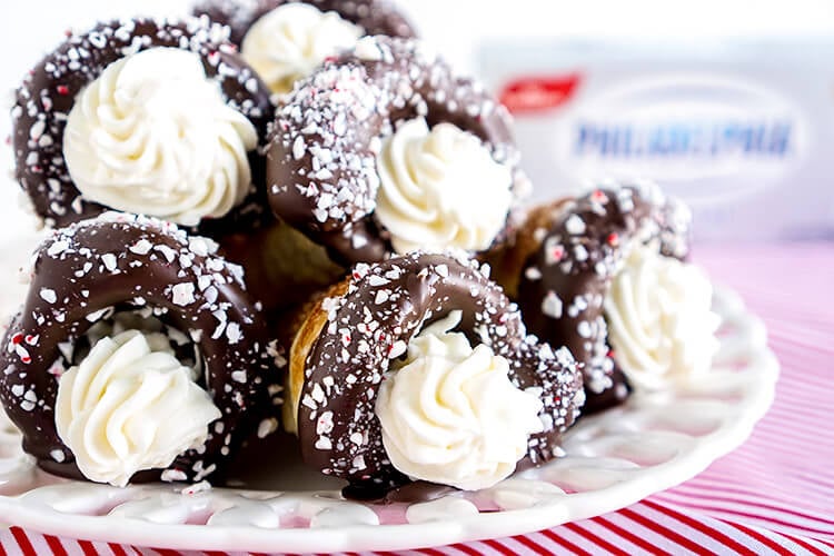 These Chocolate Peppermint Cheesecake Cream Horns are a simple dessert with a flaky pastry that’s been dipped in chocolate, sprinkled with peppermint candy pieces, and finished with a peppermint cream cheese filling.