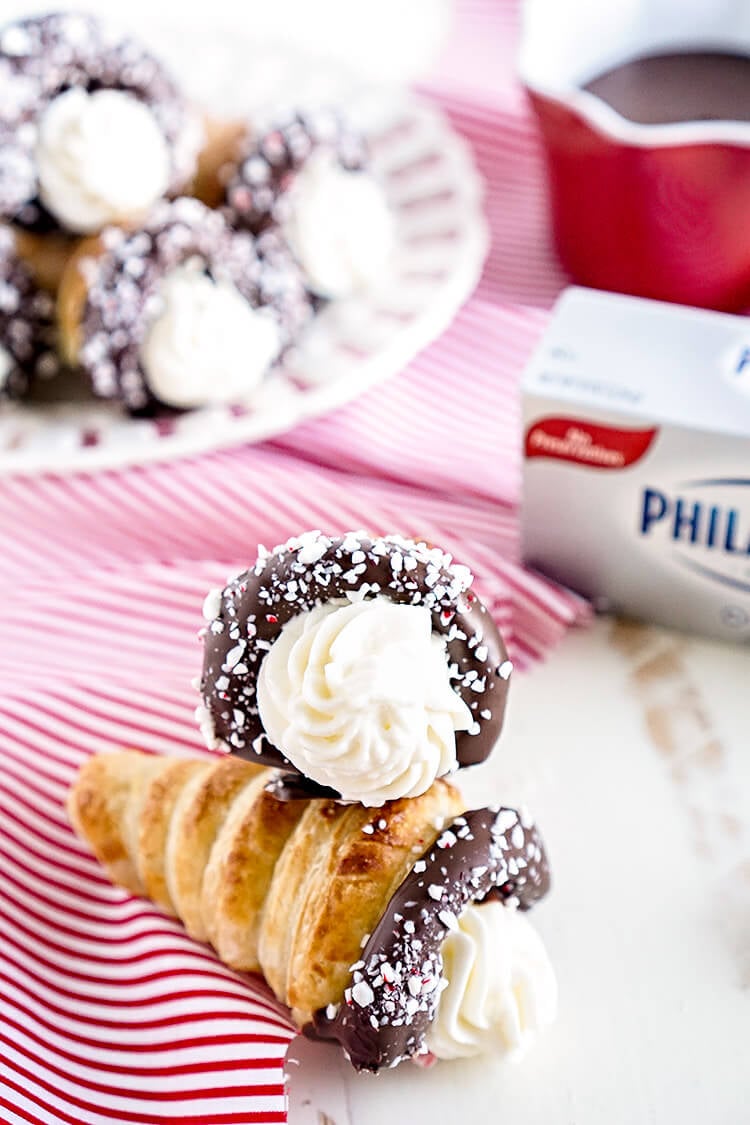 These Chocolate Peppermint Cheesecake Cream Horns are a simple dessert with a flaky pastry that’s been dipped in chocolate, sprinkled with peppermint candy pieces, and finished with a peppermint cream cheese filling.