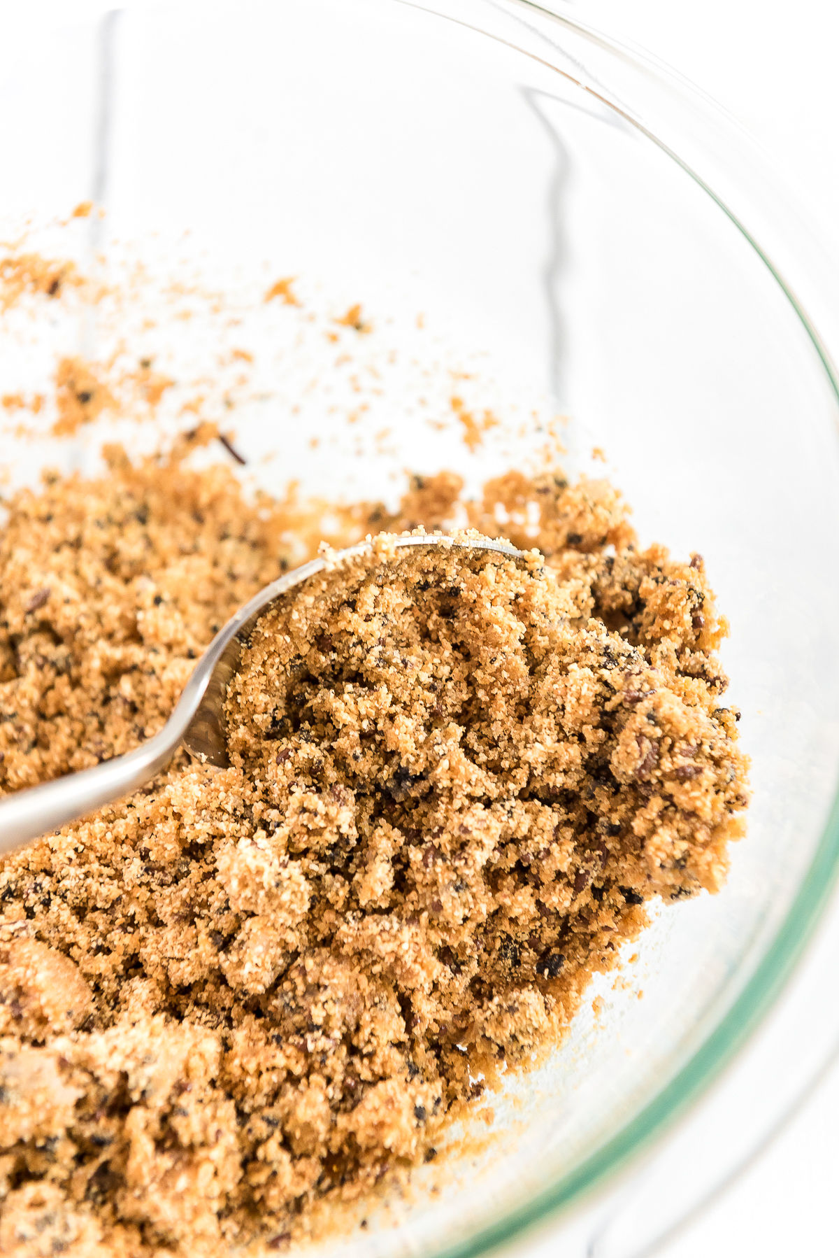 Graham cracker crumbs to make crust in a mixing bowl with a spoon.