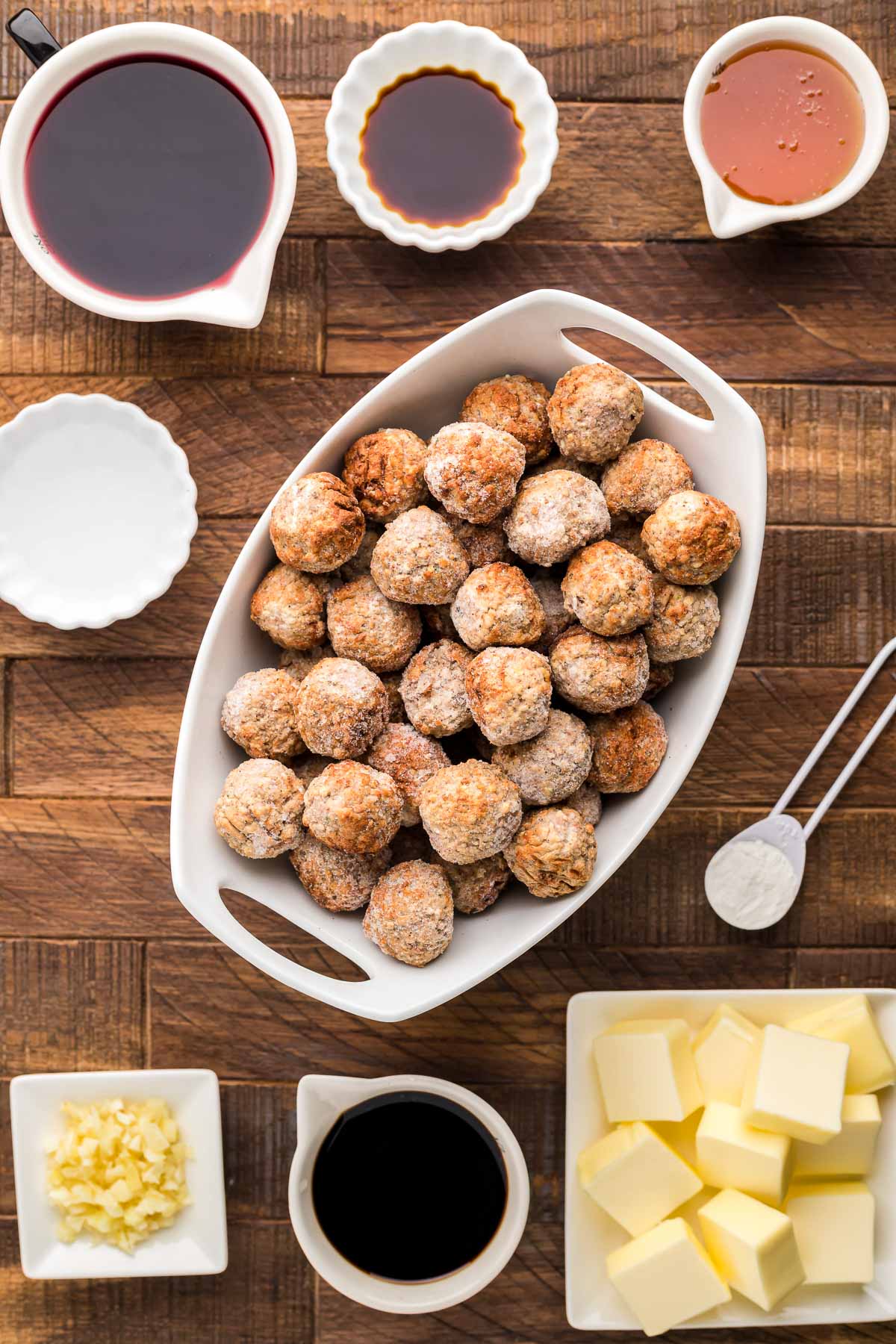 Ingredients to make Merlot Meatballs on a wooden surface.