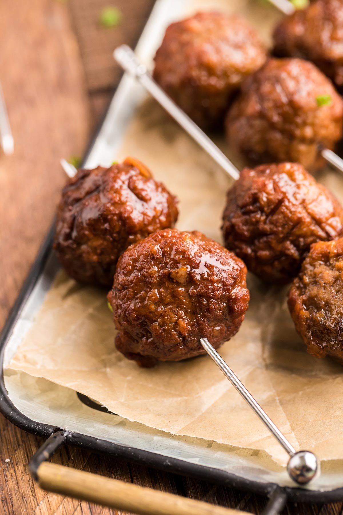 Merlot Meatballs on appetizer picks on parchment paper.