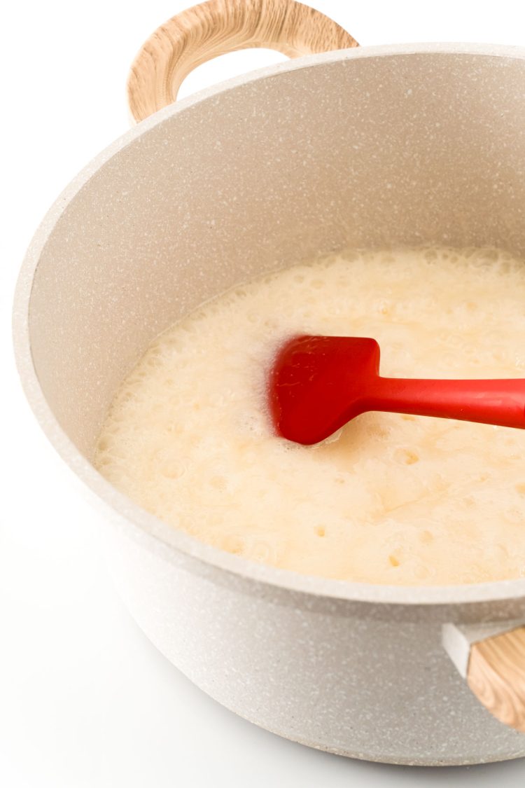 Butter, sugar, and milk boiling in a large saucepan.