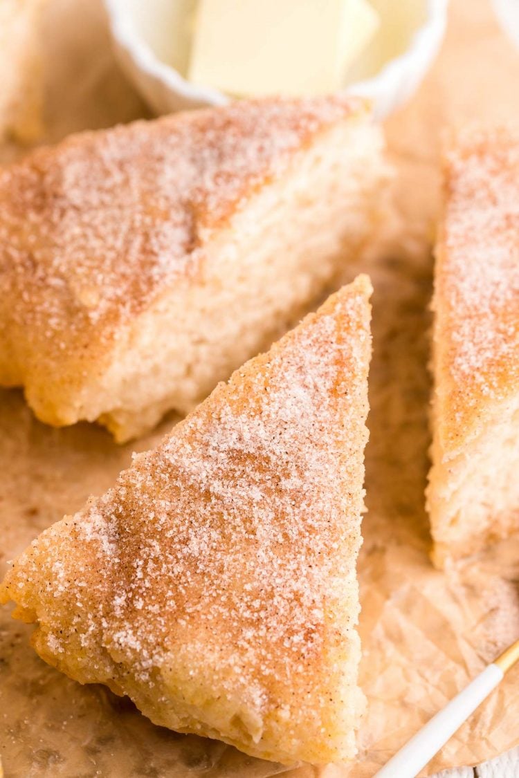 Close up photo of slices of bannock bread topped with cinnamon sugar on parchment paper.