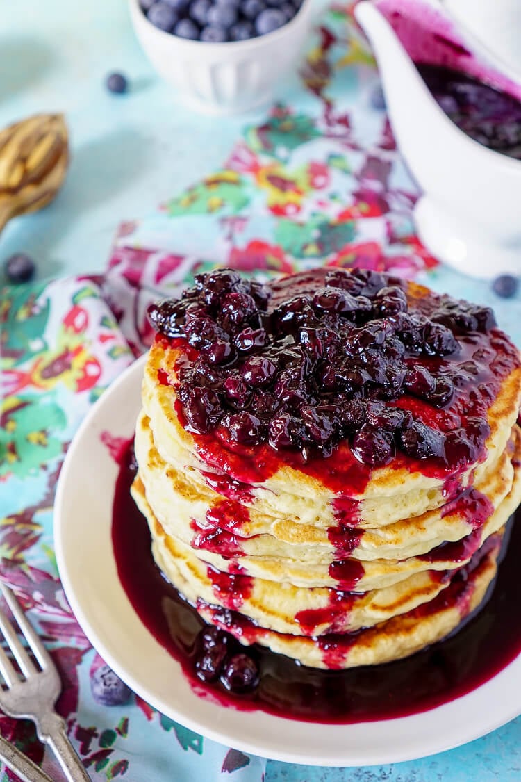 These Lemon Ricotta Pancakes are fluffy and laced with zest, then topped with a homemade Blueberry Honey Syrup for a sweet finish!