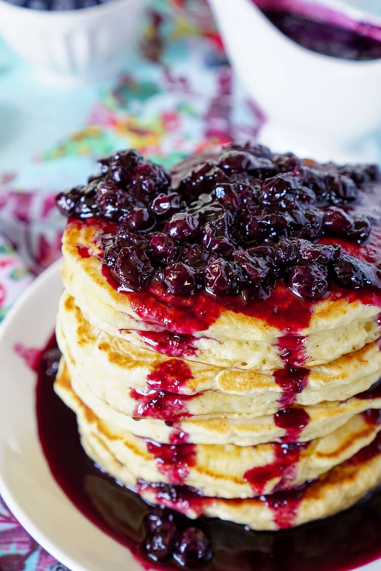 These Lemon Ricotta Pancakes are fluffy and laced with zest, then topped with a homemade Blueberry Honey Syrup for a sweet finish!