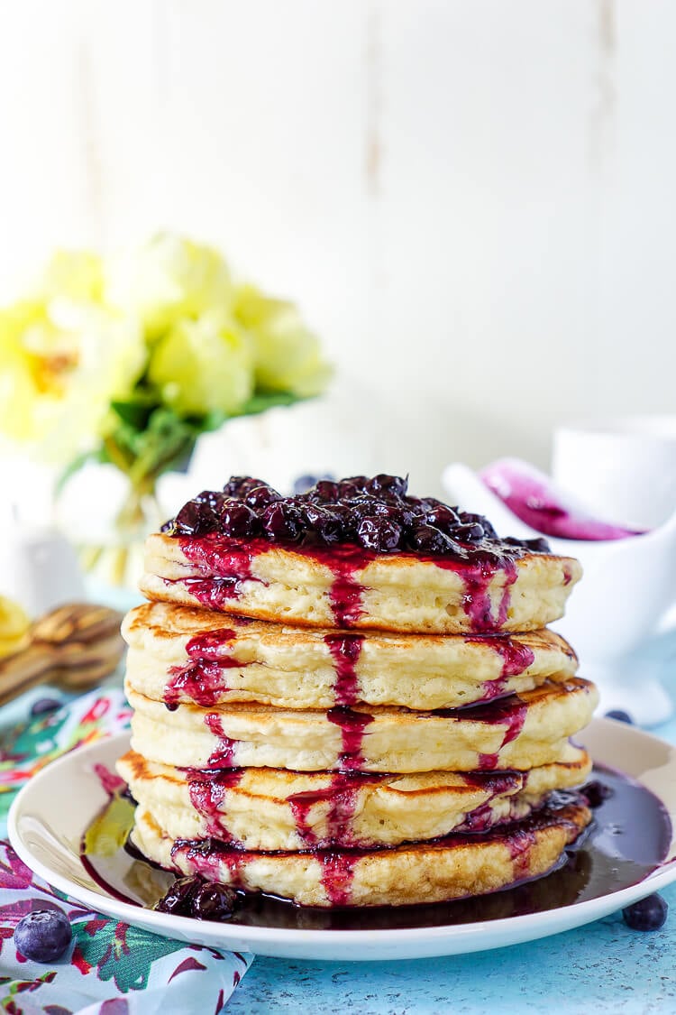 These Lemon Ricotta Pancakes are fluffy and laced with zest, then topped with a homemade Blueberry Honey Syrup for a sweet finish!