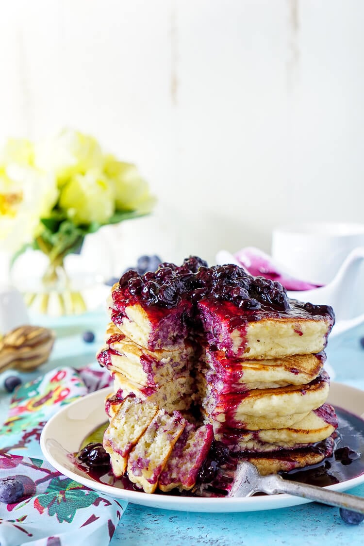 These Lemon Ricotta Pancakes are fluffy and laced with zest, then topped with a homemade Blueberry Honey Syrup for a sweet finish!