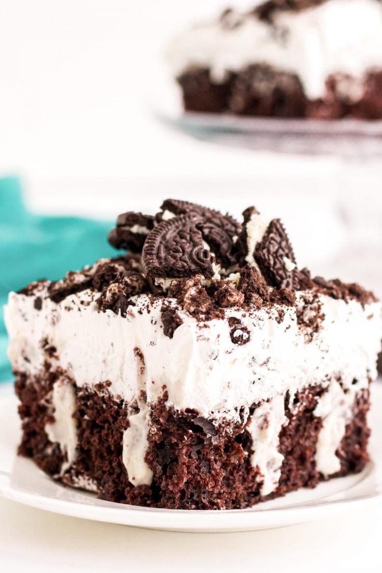 Close up photo of a piece of Oreo poke cake sitting on a white plate.
