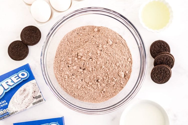 Overhead photo of ingredients used to make Oreo Poke Cake on a marble counter.