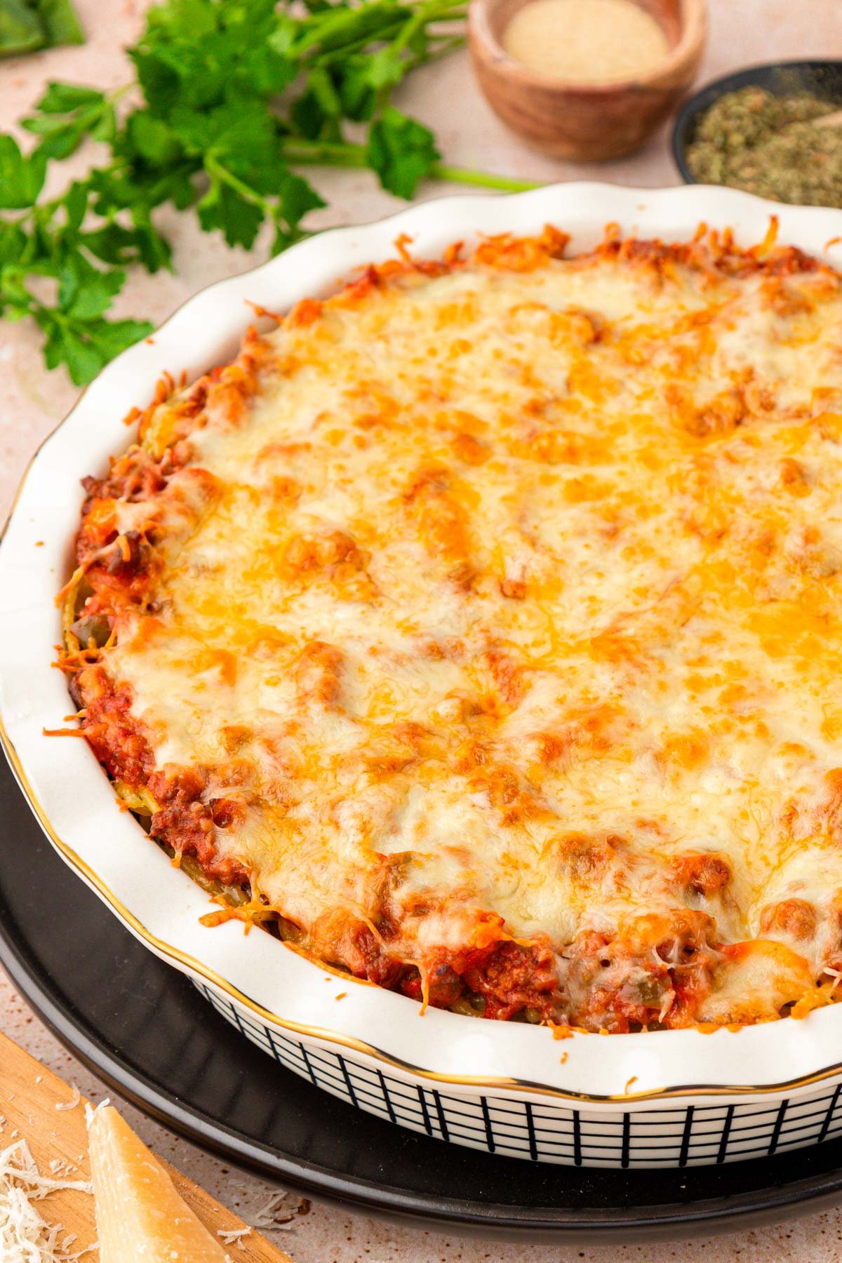 A close up photo of spaghetti pie in a white pie dish.