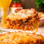 Spaghetti Pie on a spatula being lifted from a pie dish.