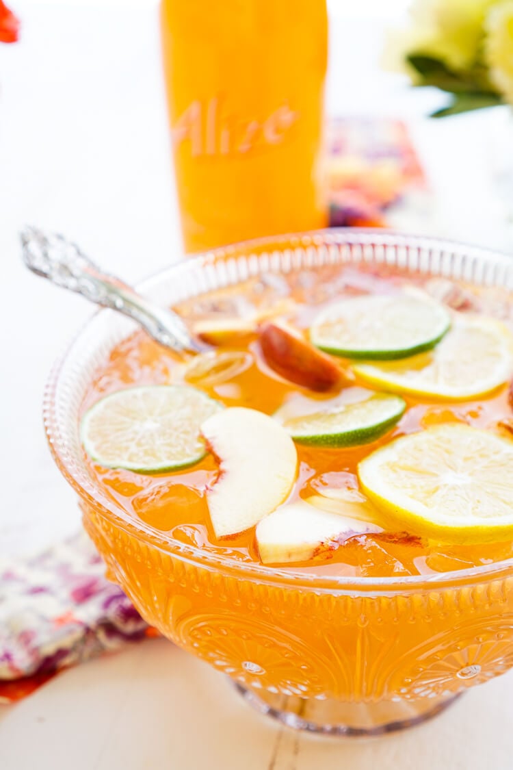 This Peach Rum Punch is the perfect big batch cocktail for summer! Smooth Alizé Peach vodka blends with white rum, lime juice, and ginger ale for a refreshing and vibrant warm weather beverage!