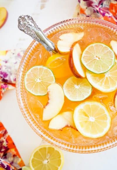 This Peach Rum Punch is the perfect big batch cocktail for summer! Smooth Alizé Peach vodka blends with white rum, lime juice, and ginger ale for a refreshing and vibrant warm weather beverage!