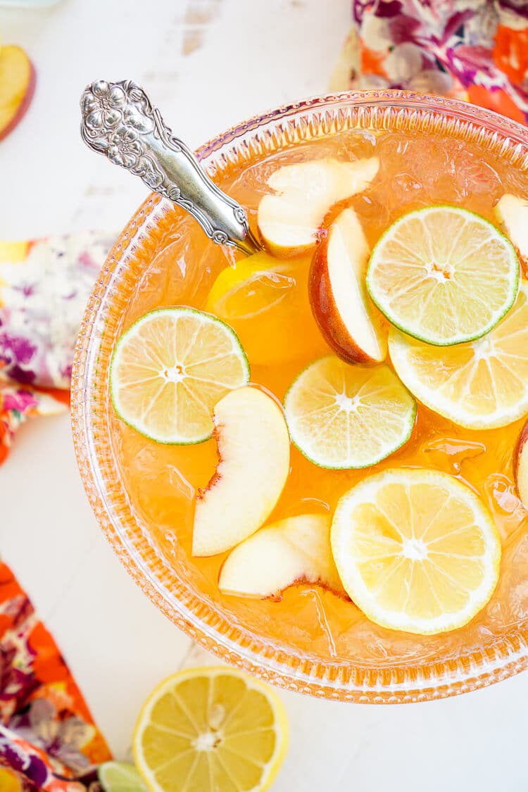 This Peach Rum Punch is the perfect big batch cocktail for summer! Smooth Alizé Peach vodka blends with white rum, lime juice, and ginger ale for a refreshing and vibrant warm weather beverage!