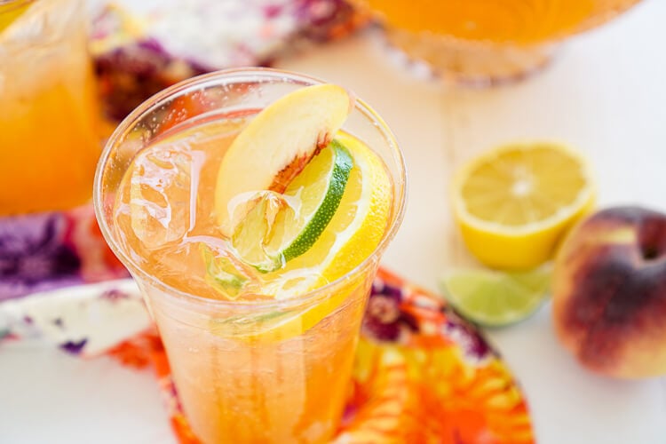 This Peach Rum Punch is the perfect big batch cocktail for summer! Smooth Alizé Peach vodka blends with white rum, lime juice, and ginger ale for a refreshing and vibrant warm weather beverage!