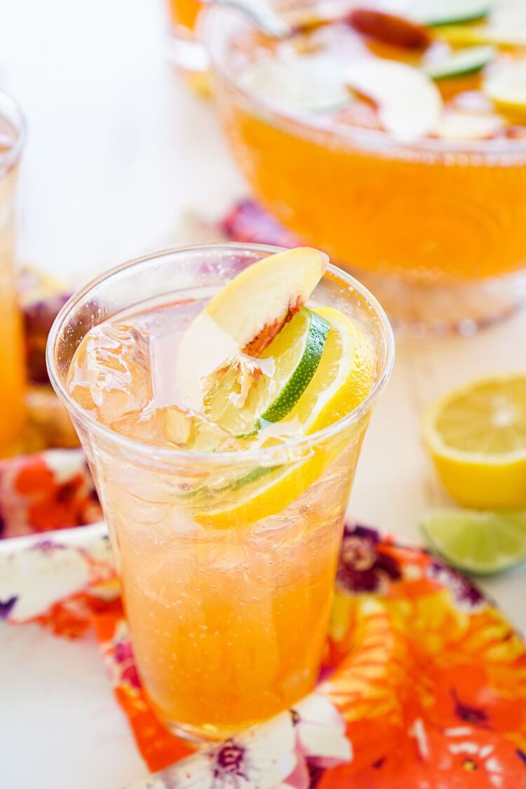 This Peach Rum Punch is the perfect big batch cocktail for summer! Smooth Alizé Peach vodka blends with white rum, lime juice, and ginger ale for a refreshing and vibrant warm weather beverage!