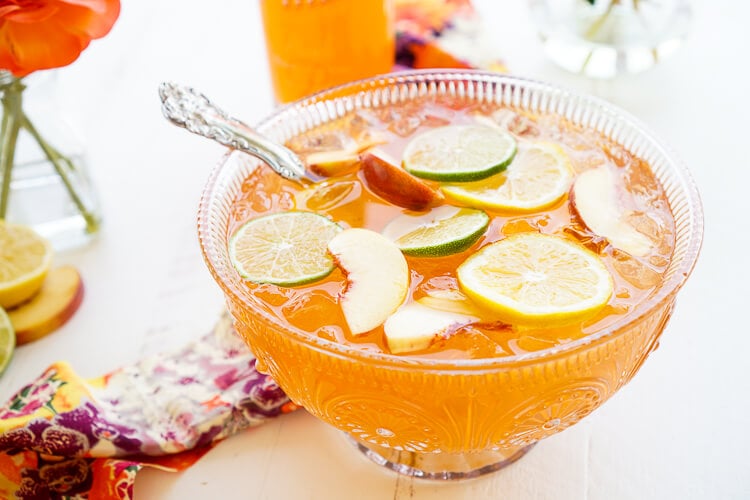 This SpikedPeach Punch is the perfect big batch cocktail for summer! Smooth Alizé Peach vodka blends with white rum, lime juice, and ginger ale for a refreshing and vibrant warm weather beverage!