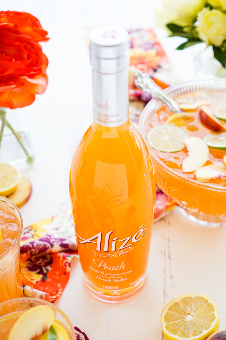 This Peach Rum Punch is the perfect big batch cocktail for summer! Smooth Alizé Peach vodka blends with white rum, lime juice, and ginger ale for a refreshing and vibrant warm weather beverage!