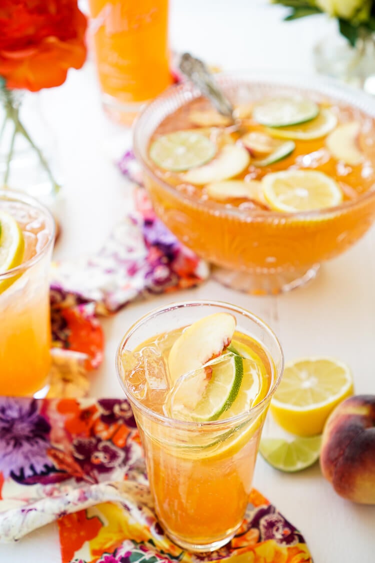 This Spiked Peach Punch is the perfect big batch cocktail for summer! Smooth Alizé Peach vodka blends with white rum, lime juice, and ginger ale for a refreshing and vibrant warm weather beverage!