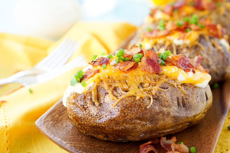 These are the Best Ever Baked Potatoes, they're perfectly seasoned and loaded up with a creamy dressing, cheddar cheese, bacon, and chives!