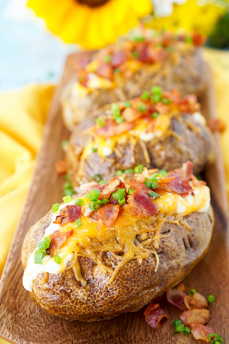 These are the Best Ever Baked Potatoes, they're perfectly seasoned and loaded up with a creamy dressing, cheddar cheese, bacon, and chives!