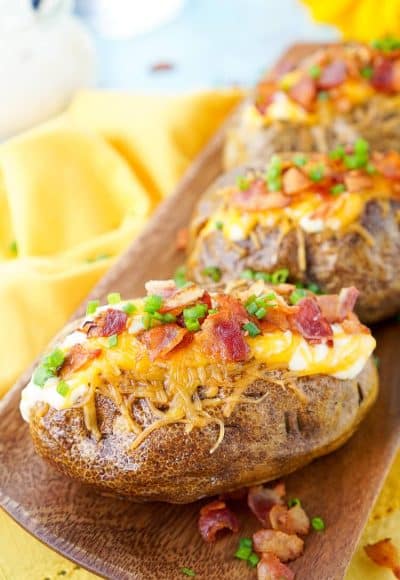 These are the Best Ever Baked Potatoes, from the prep work to the toppings, they're perfectly seasoned and loaded up with a creamy dressing, cheddar cheese, bacon, and chives!