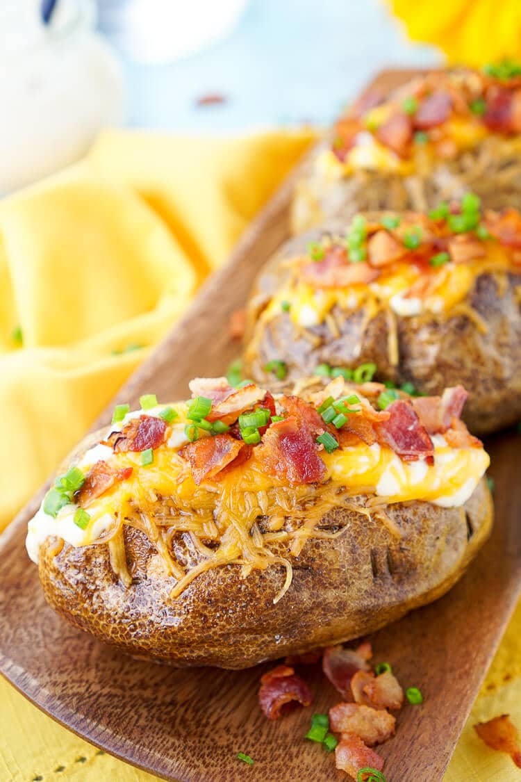 These are the Best Ever Baked Potatoes, they're perfectly seasoned and loaded up with a creamy dressing, cheddar cheese, bacon, and chives!