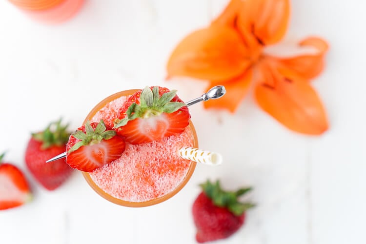 Overhead photo of a strawberry daiquiri garnished with fresh strawberries.