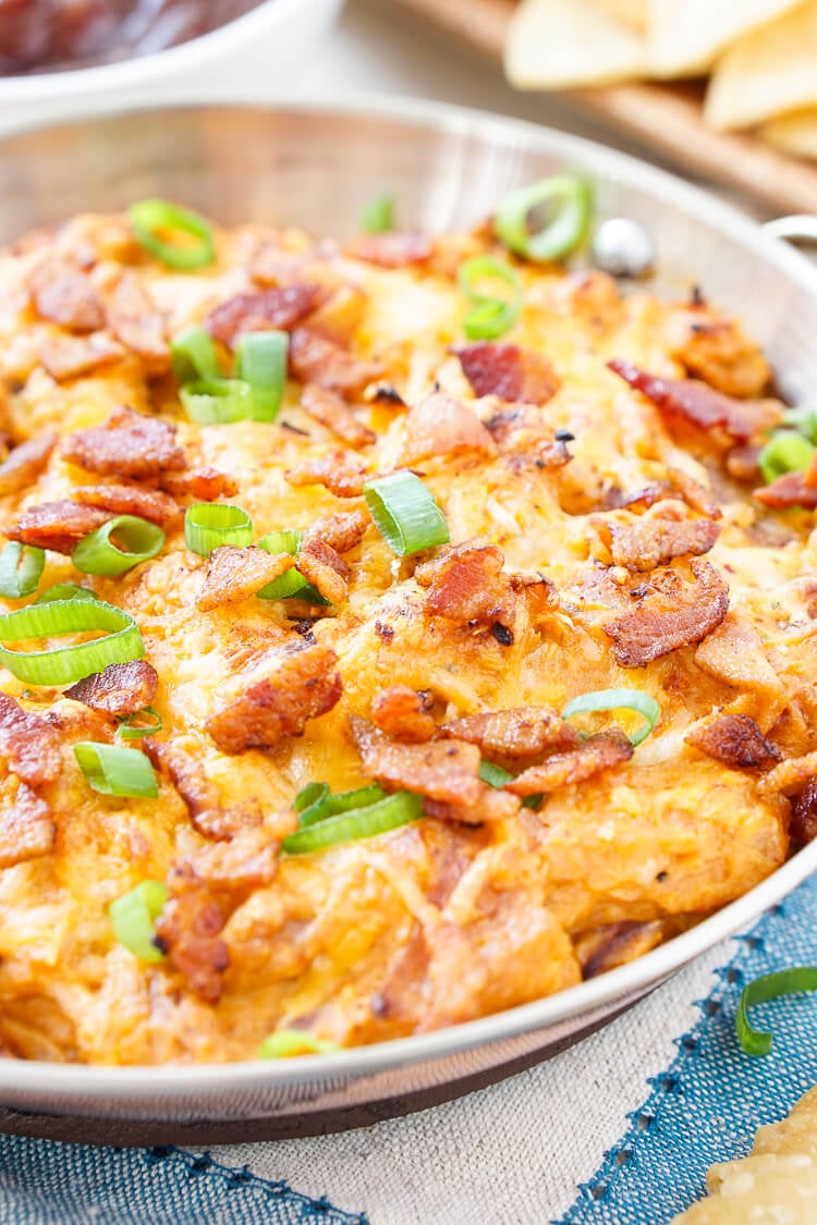 This Cheesy Bacon BBQ Chicken Dip will be the winning dish at your next game day party! Cheesy goodness loaded up with caramelized onions, crunchy bacon, shredded chicken, and tangy barbecue sauce! Only 10 minutes of prep!