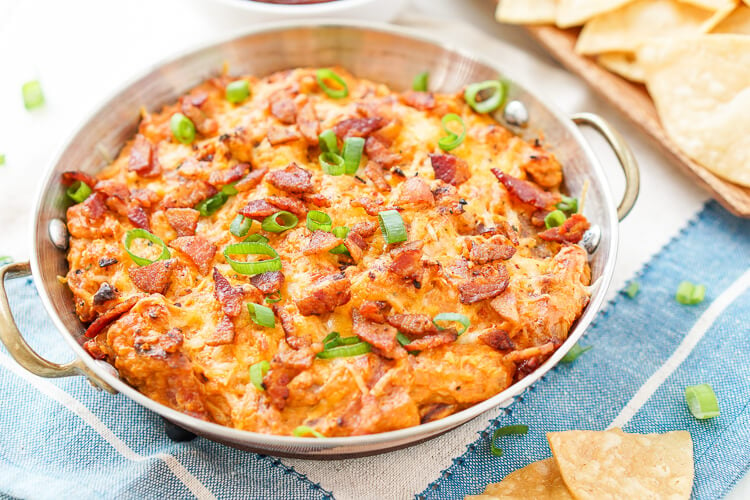 This Cheesy Bacon BBQ Chicken Dip will be the winning dish at your next game day party! Cheesy goodness loaded up with caramelized onions, crunchy bacon, shredded chicken, and tangy barbecue sauce! Only 10 minutes of prep!