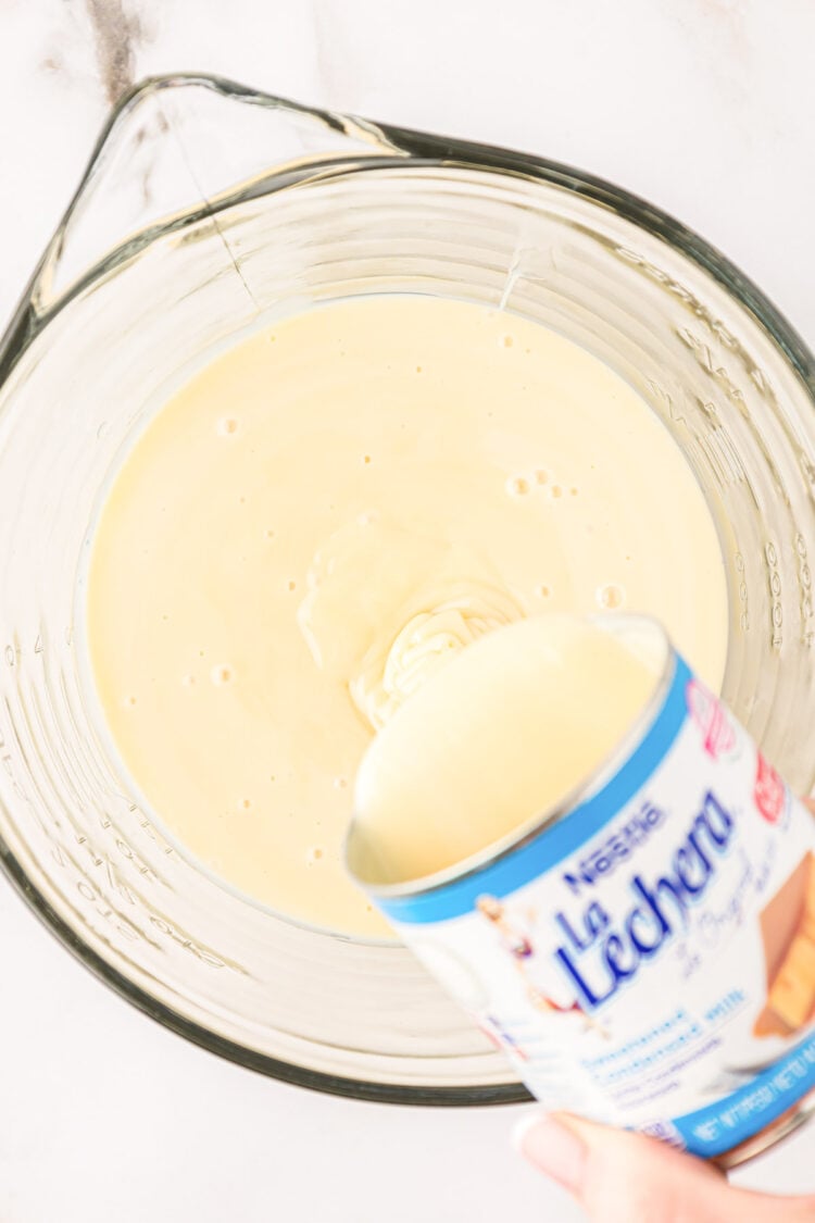 Sweetened condensed milk being poured into a bowl.