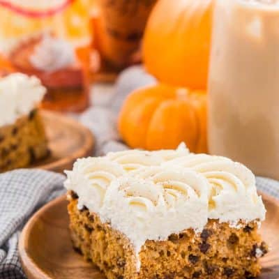 This Pumpkin Chocolate Chip Poke Cake is a deliciously seasonal dessert that's great for potlucks and family gatherings. A dense pumpkin spice cake soaked in sweetened condensed milk and loaded with chocolate chips is topped with a fluffy cheesecake frosting and dusted with cinnamon!